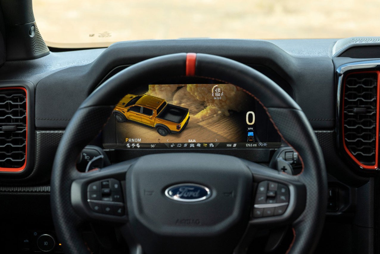 Interior view of a Ford Ranger, showing the digital dashboard with a simulated off-road scene and vehicle information. 