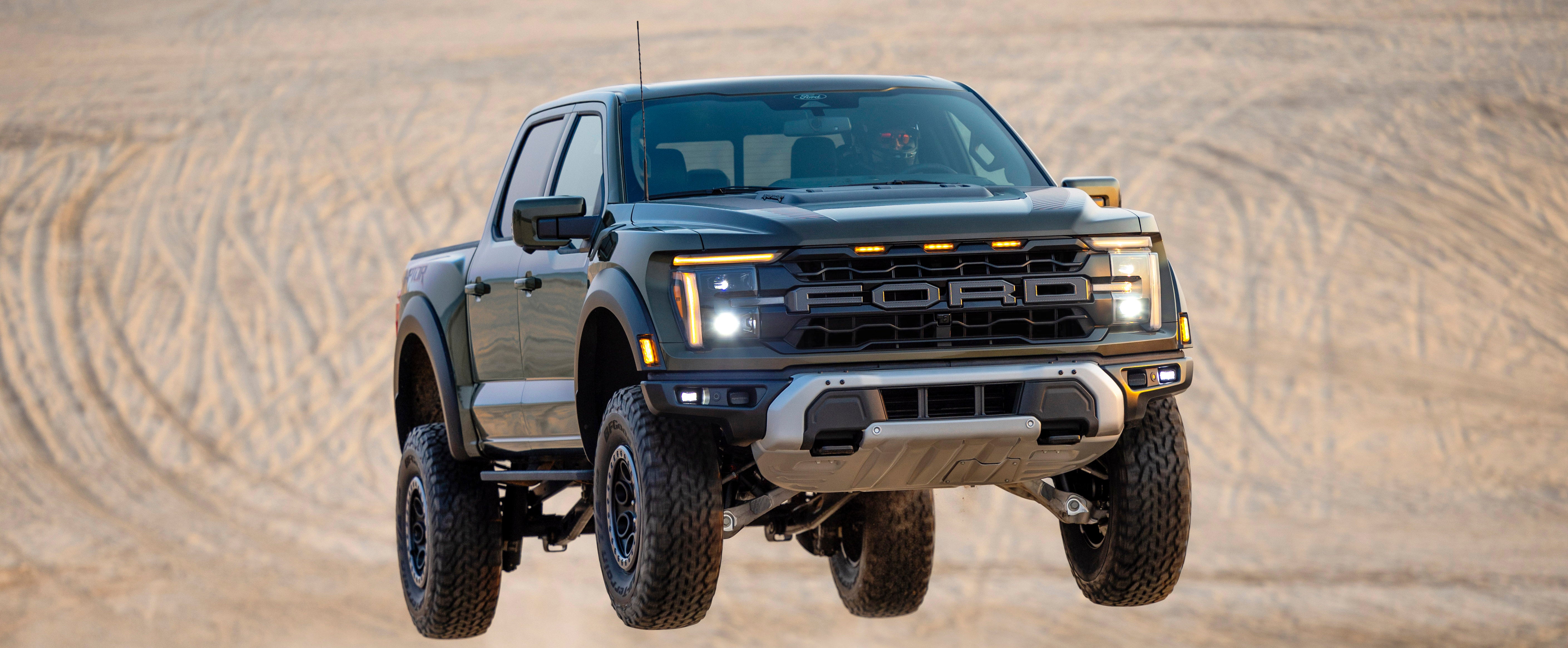A Ford F-150 Lightning highlighting its high ground clearance and sealed battery pack as it confidently navigates through a flooded area.