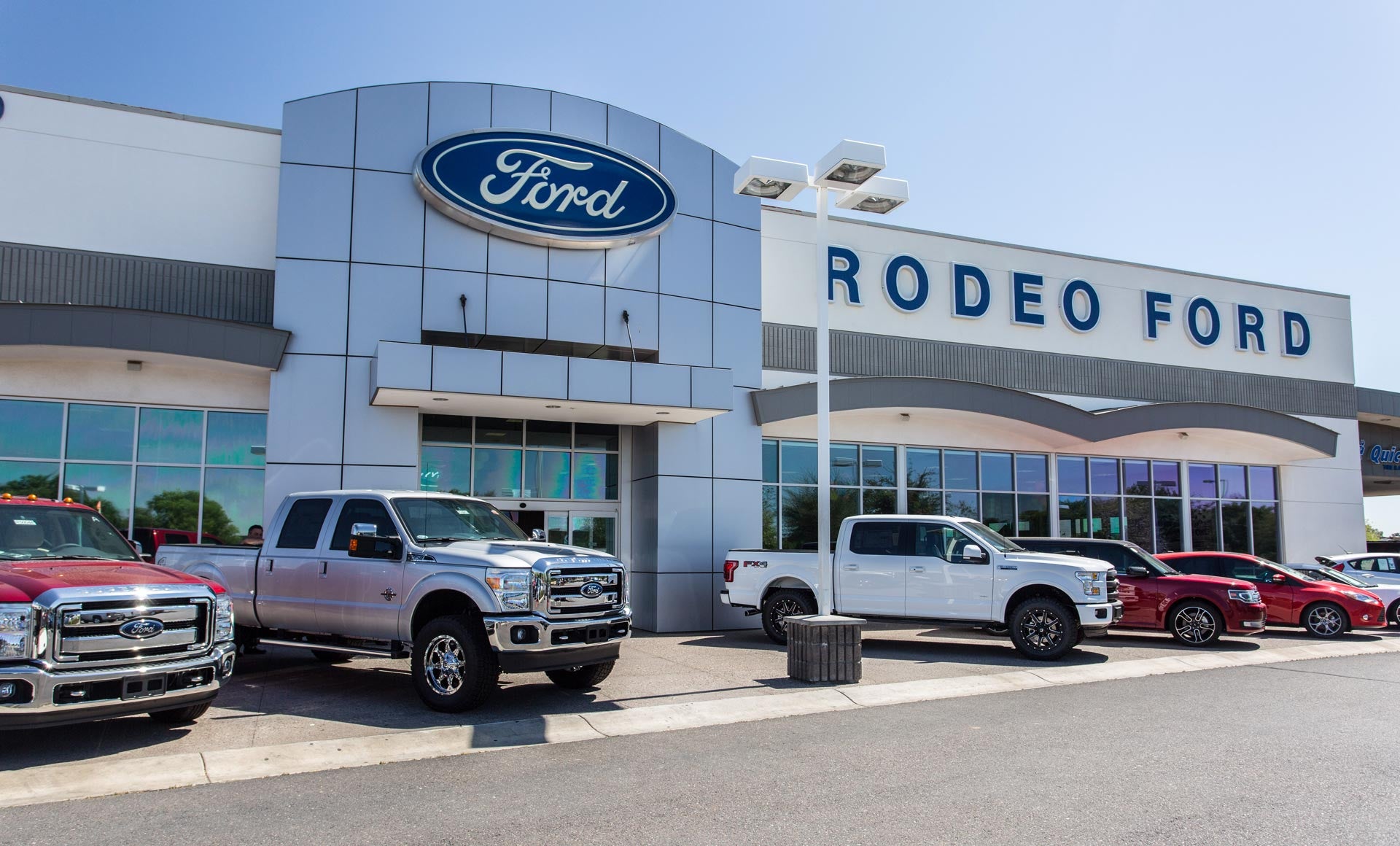 Vehicles are parked front of Rodeo Ford Building